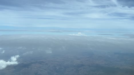 Flying-between-layers-of-clousds-in-a-sunny-autumn-afternoon,-shot-from-an-airplane-cockpit-at-5000m-high