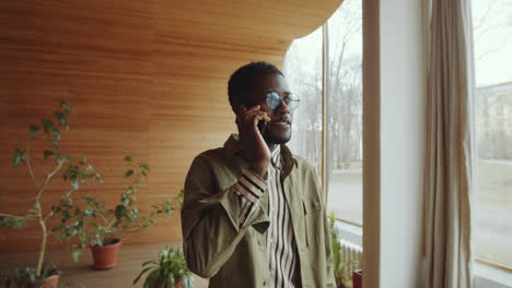 afro man walking in library auditorium and talking on phone