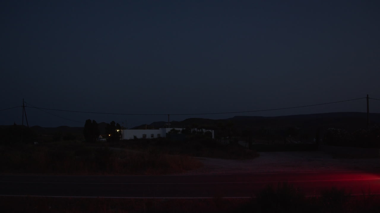 Vista notturna di un'auto che guida su una strada di campagna isolata