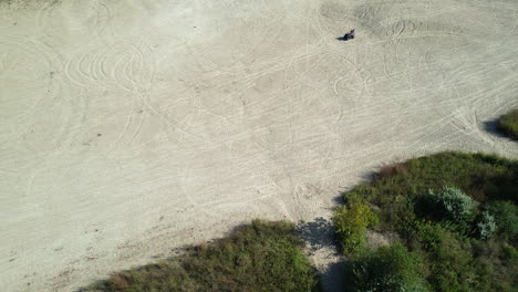 aerial view of people on a quad driving through the white sand dunes at the big river management area.