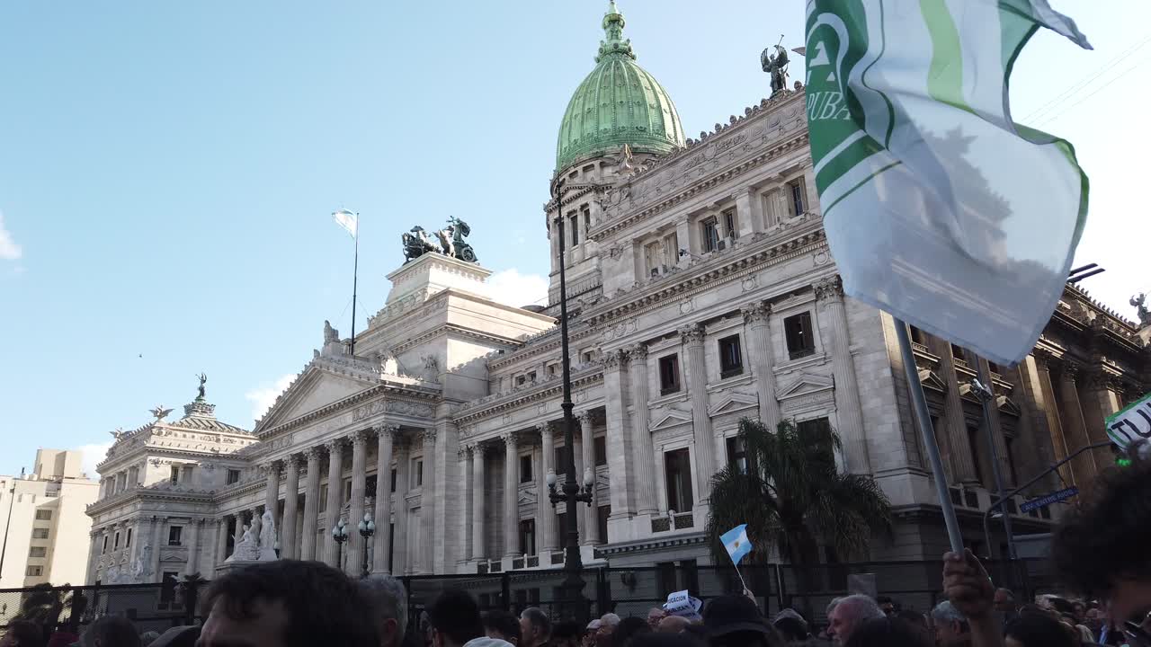 National congress of buenos aires city argentina with political flags waving people gather to protest in favor of Public University