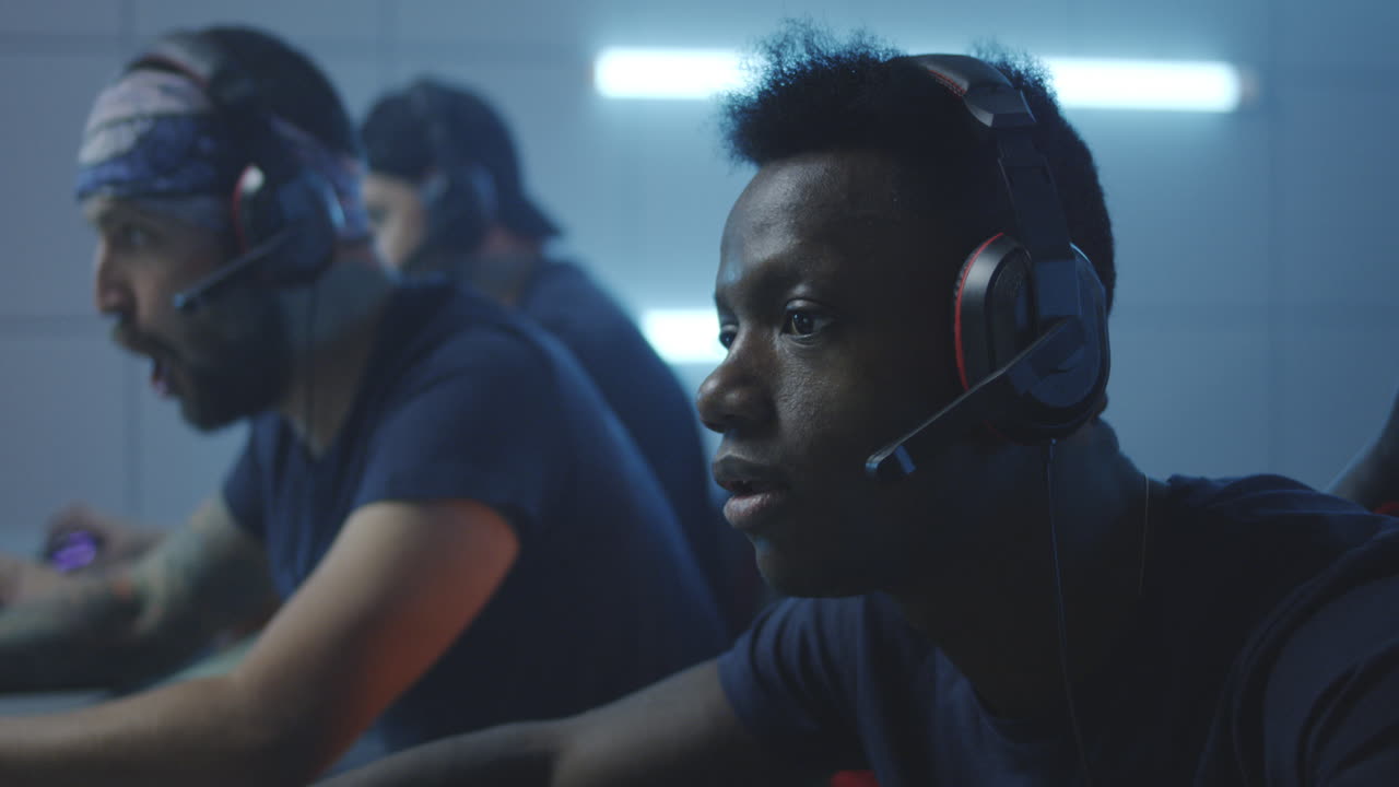 Gamers playing in a dark room with blue lighting