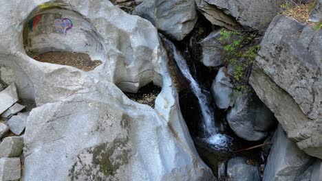 vista aérea móvil de la roca central en la cresta de california - formación rocosa natural con cascada que fluye