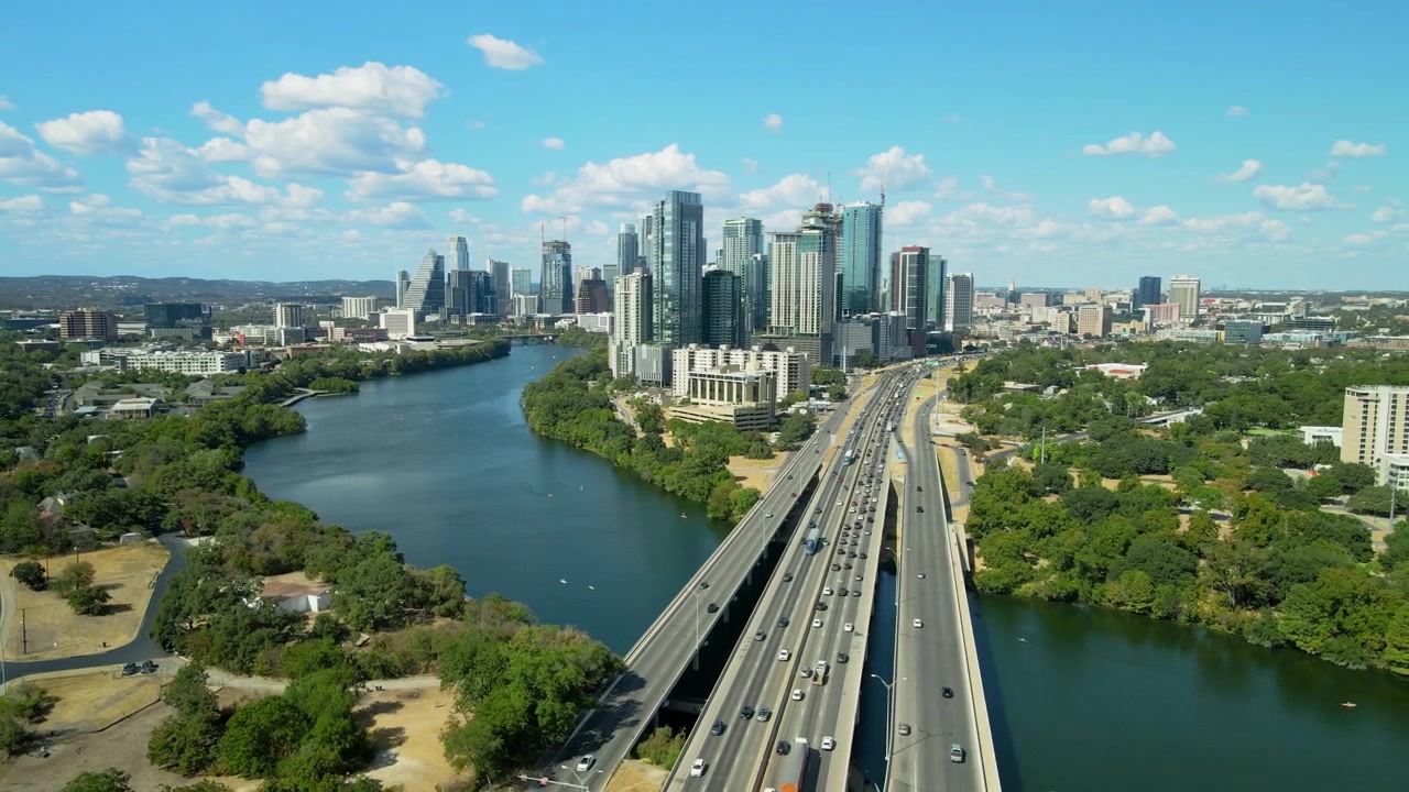 Vista aérea de drone estabelecendo o centro de Austin, Texas, com a Rodovia I35 do Rio Colorado e o centro ao fundo durante o dia, paisagem urbana americana.