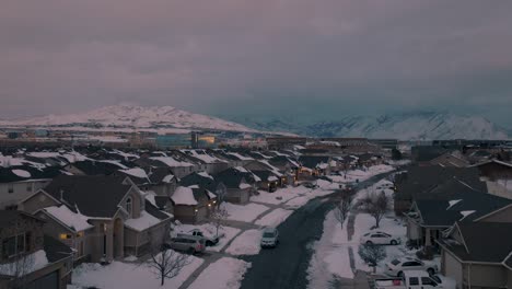 Día-De-Nieve-En-Un-Barrio-Suburbano-En-Un-Valle-Debajo-De-Las-Montañas---Revelación-Aérea-Ascendente