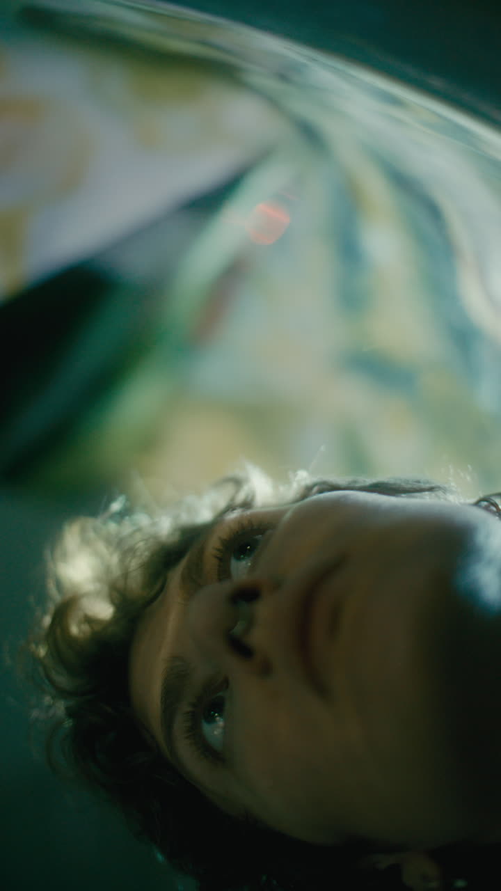 Dreamy Girl Looking through Glass Illuminated by Light Streaks