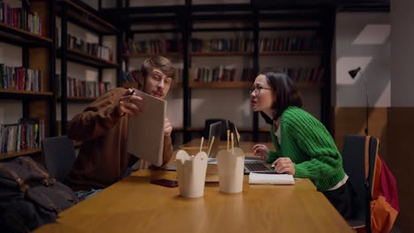 students studying in library with food