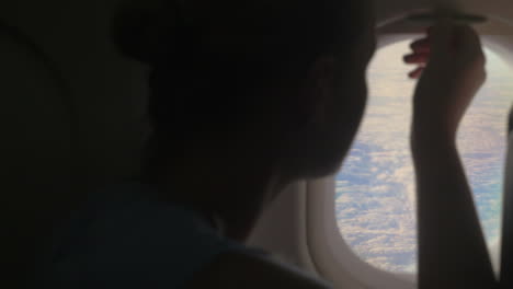 woman looking out illuminator in plane