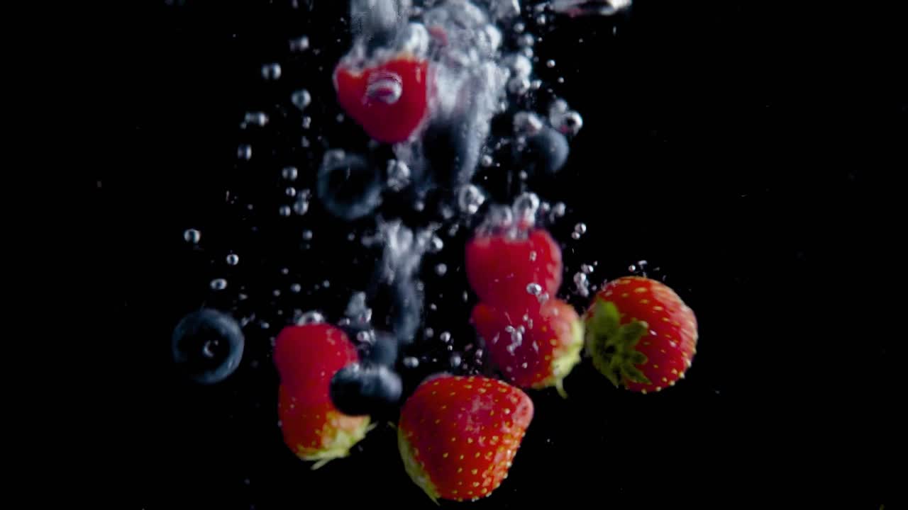 Strawberries Falling into Water Super Slowmotion, Black Background, lots of Air Bubbles, 4k240fps