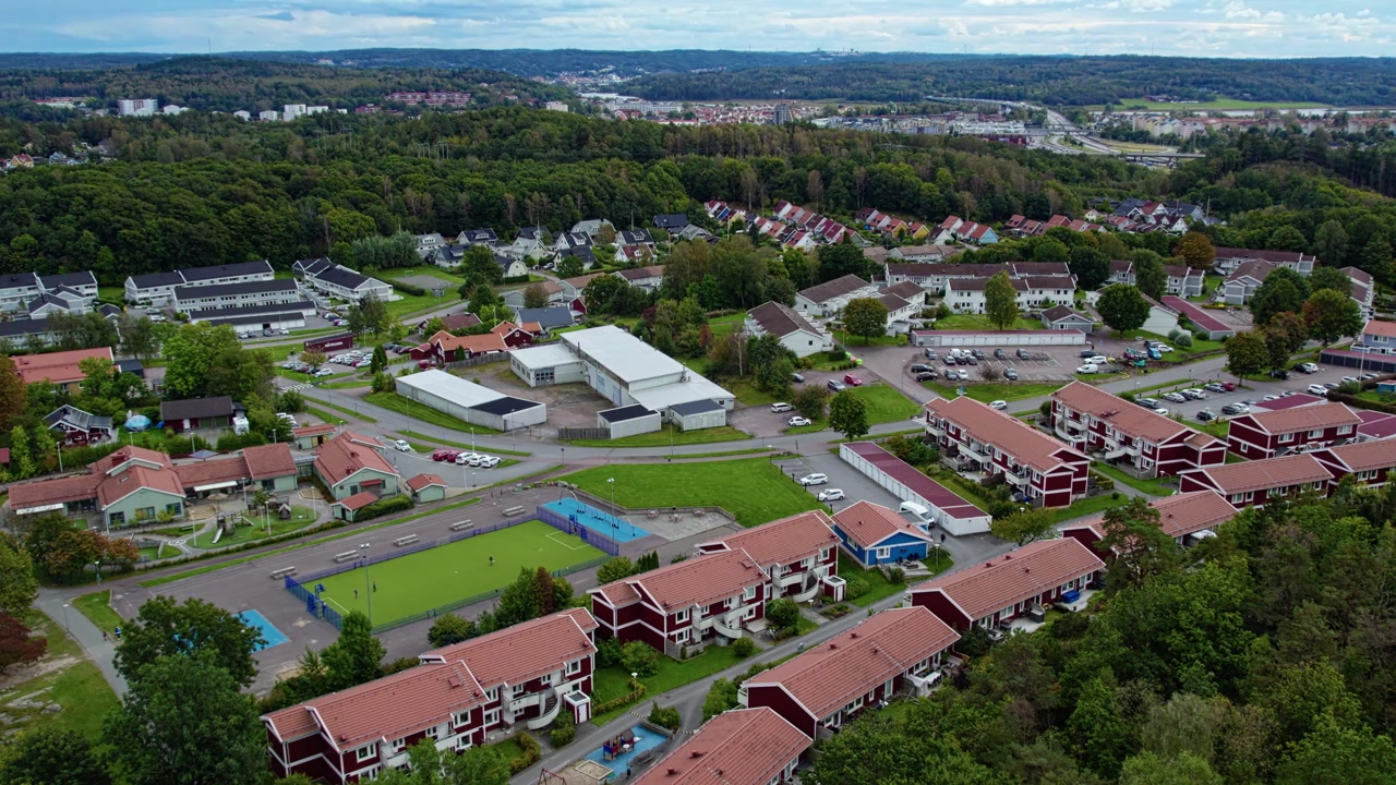Aerial drone shot of residential neighborhood in Kungalv with houses apartment buildings streets green spaces and community layout in calm suburban landscape