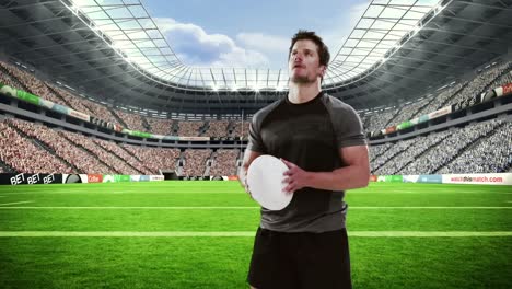 serious rugby player holds rugby ball