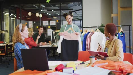 Happy-diverse-business-people-discussing-work-with-clothes-at-office