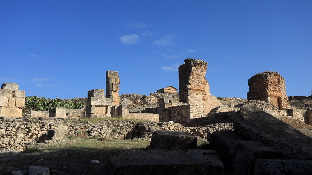 antiguas ruinas romanas en dougga bajo un cielo azul, mostrando arquitectura histórica