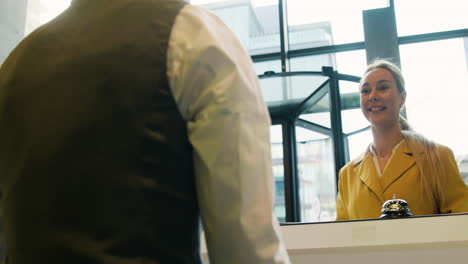 Back-view-of-receptionist-attending-a-guest