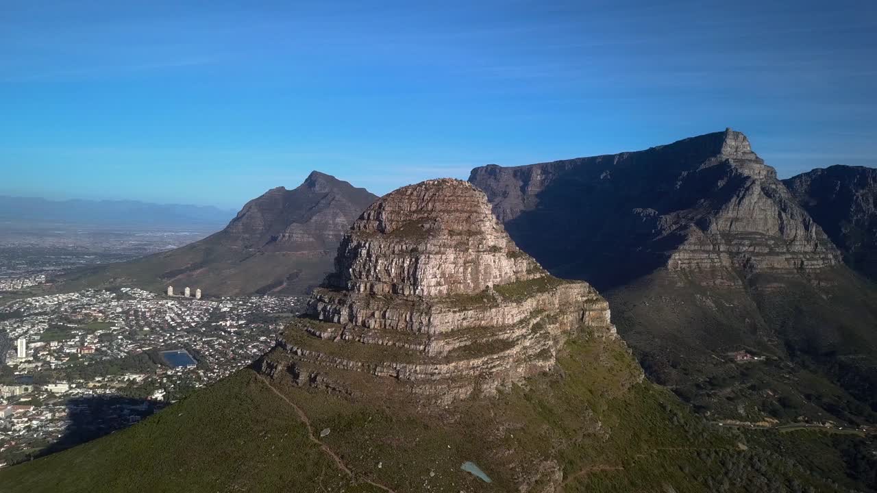 Flying towards Summit of Lions Head Mountain in Cape Town South Africa, Revealing Table Mountain and The Twelve Apostles. Drone Aerial
