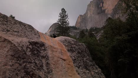 panning shot from a large granite boulder to half dome towering above