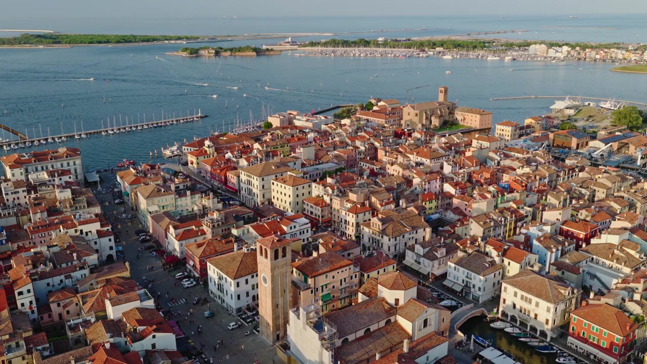 Splendide riprese aeree con drone di Chioggia, Italia, che mostrano il centro storico, i campanili, i tetti colorati e la Laguna di Venezia durante la calda ora d'oro