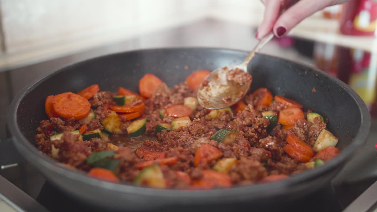carne picada con zanahorias cocinando en sartén