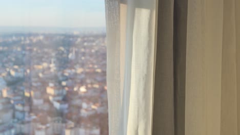 city view through a window with sheer curtains