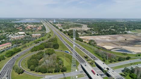 aerial shot creeping forward towards a radio tower next to highway in florida on a sunny day