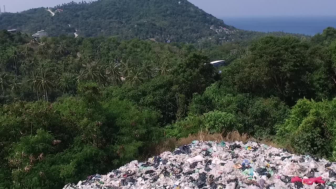 drone vuela hacia adelante sobre una montaña de basura entre árboles isla fondo 1080 hd asia, tailandia filmada con sony ax700