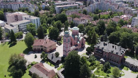 aerial view circling orthodox christian church of holy trinity looking down over green domed rooftop in banja luka district