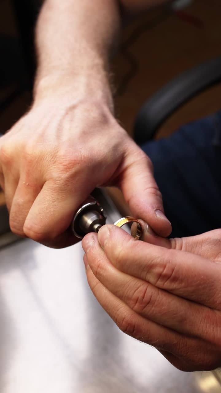 Close-Up of Jeweler's Hands Working on a Golden Ring with a Tool