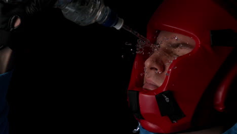 boxer pouring water from bottle over face