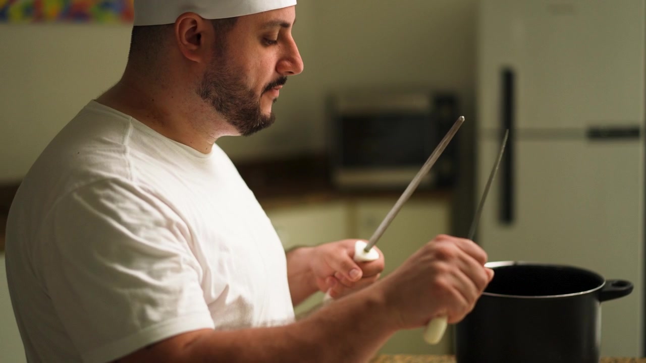 Un cuoco affila un coltello in una cucina professionale