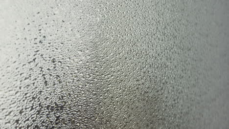 a female silhouette behind the frosted window touches the glass slowly
