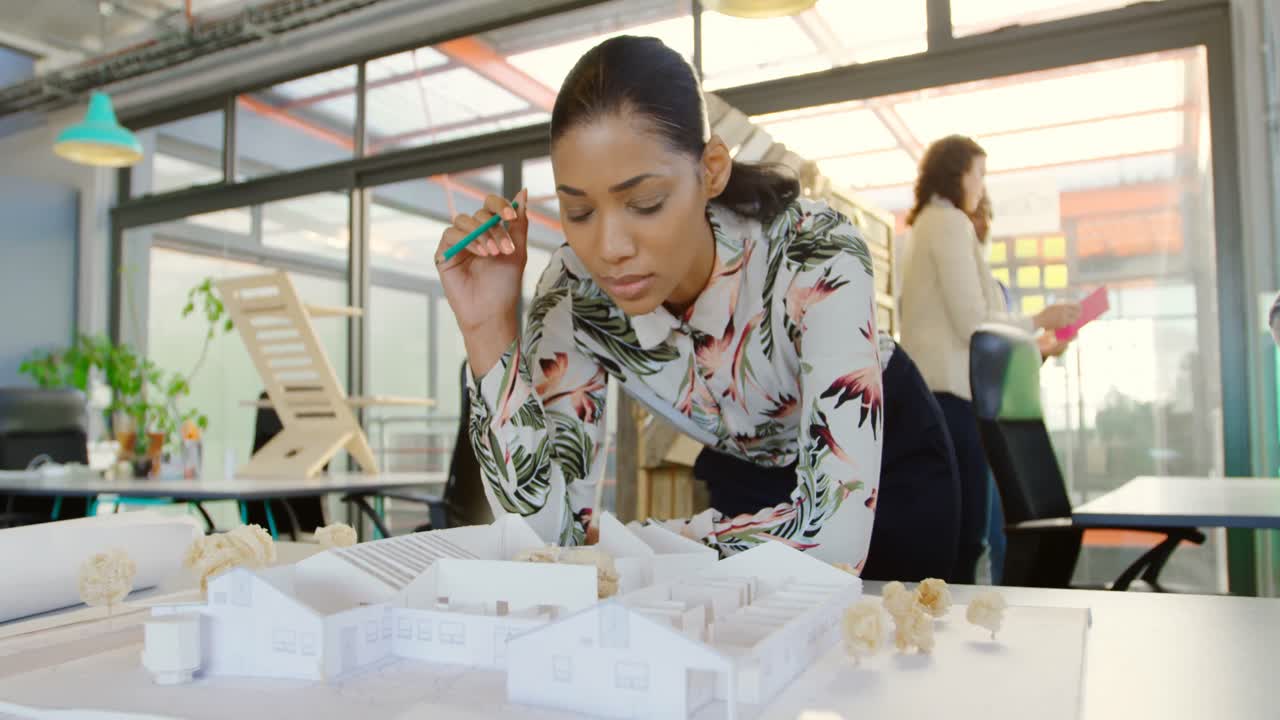 Female executive looking at architectural model 4k