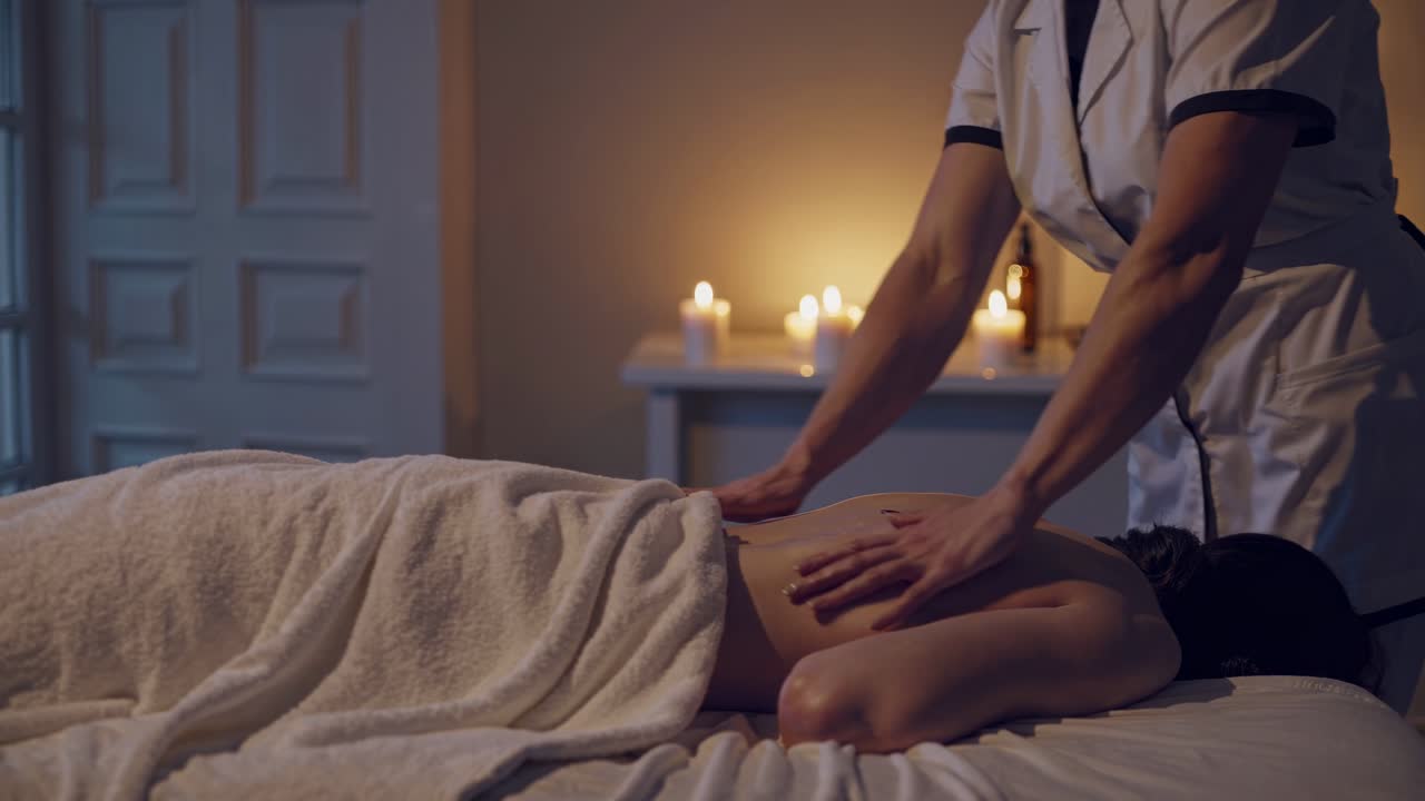 Escena de vídeo serena de un spa con un ángulo de cámara bajo de un masajista trabajando en un cliente