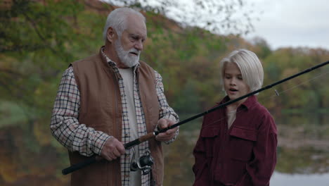 grandfather teaches grandchild how to fish