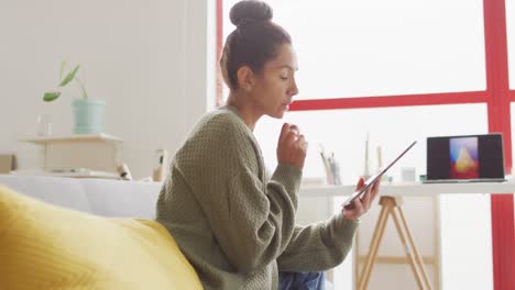 video de una feliz diseñadora biracial usando una tableta en el estudio
