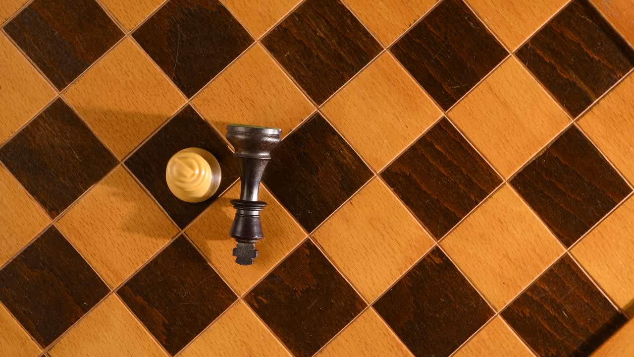 rey derrotando a otro rey en la guerra, derribado en el tablero de ajedrez