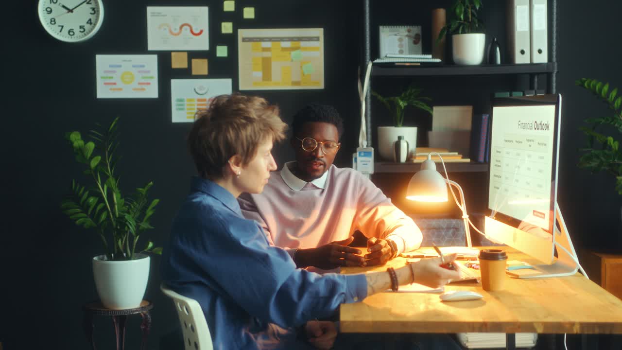 Young Colleagues Discussing Financial Presentation in Modern Office