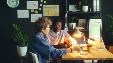 young colleagues discussing financial presentation in modern office