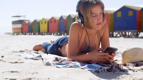 Chica-Usando-Teléfono-Móvil-En-La-Playa-4k