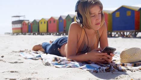 chica usando teléfono móvil en la playa 4k