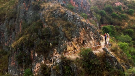 tourists hiking along a narrow trail near qhapaq ñan and inkilltambo ruins, cusco, peru