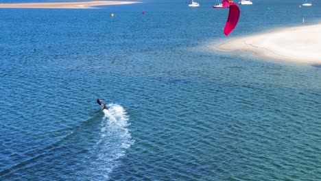windsurfista en la costa dorada aguas amplias, día de verano, seguimiento de drones