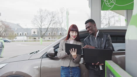 business people using tablets and laptops at a charging station