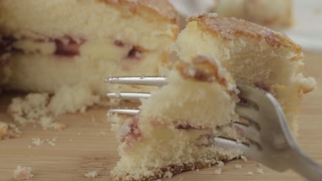 eating slice of victoria sponge cake with fork macro shot