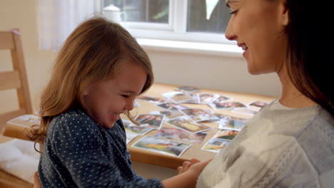 mother and daughter playing game with hands at home together