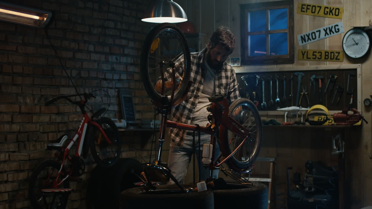 Man Fixing a Bicycle in a Garage