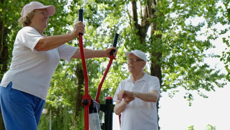 elderly couple exercising at an outdoor gym in a park