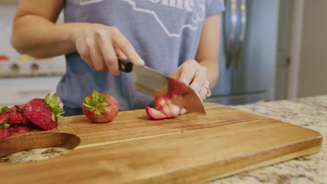 Frau-Schneidet-Frische-Erdbeeren-Auf-Schneidebrett