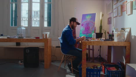 artist painting a picture at desk in creative studio