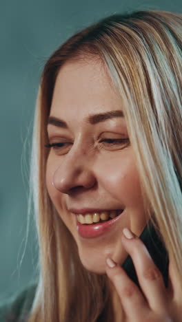 una mujer sonriente habla en su teléfono inteligente sosteniendo una imagen de ultrasonografía en un fondo borroso en la oficina de la clínica semi-oscura después de un examen de primer plano extremo en cámara lenta