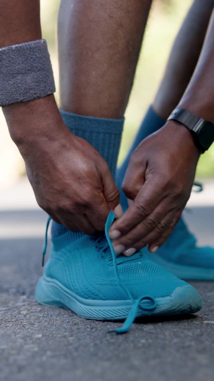 Corridore che allaccia i lacci delle scarpe su scarpe da corsa color verde acqua